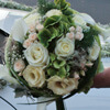 Weiß grüner Brautstrauß mit weißen Rosen, creme farbenen Lisianthus und grünen Hortensien vor der Hochzeitskutsche.