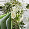 Weiße grüner Tischdeko aus Orchideen, Hortensien, Schleierkraut und Efeu.
